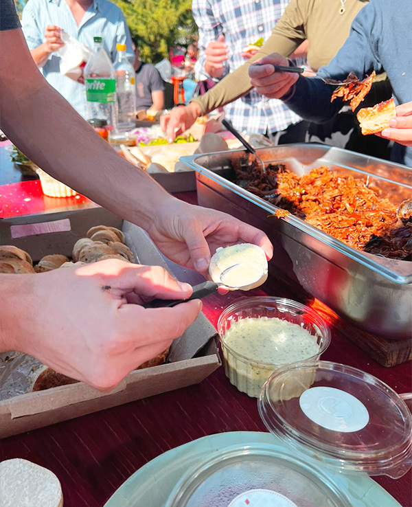 persona aplicando salsas en evento gastronomico brunua